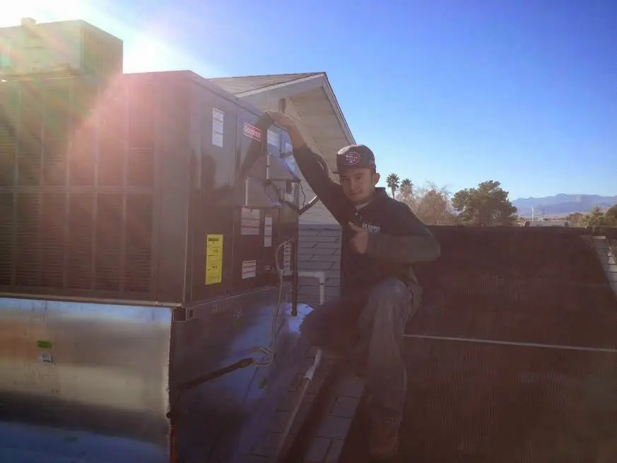HVAC technician performing AC Tune-Up on a rooftop unit in Bonita Springs